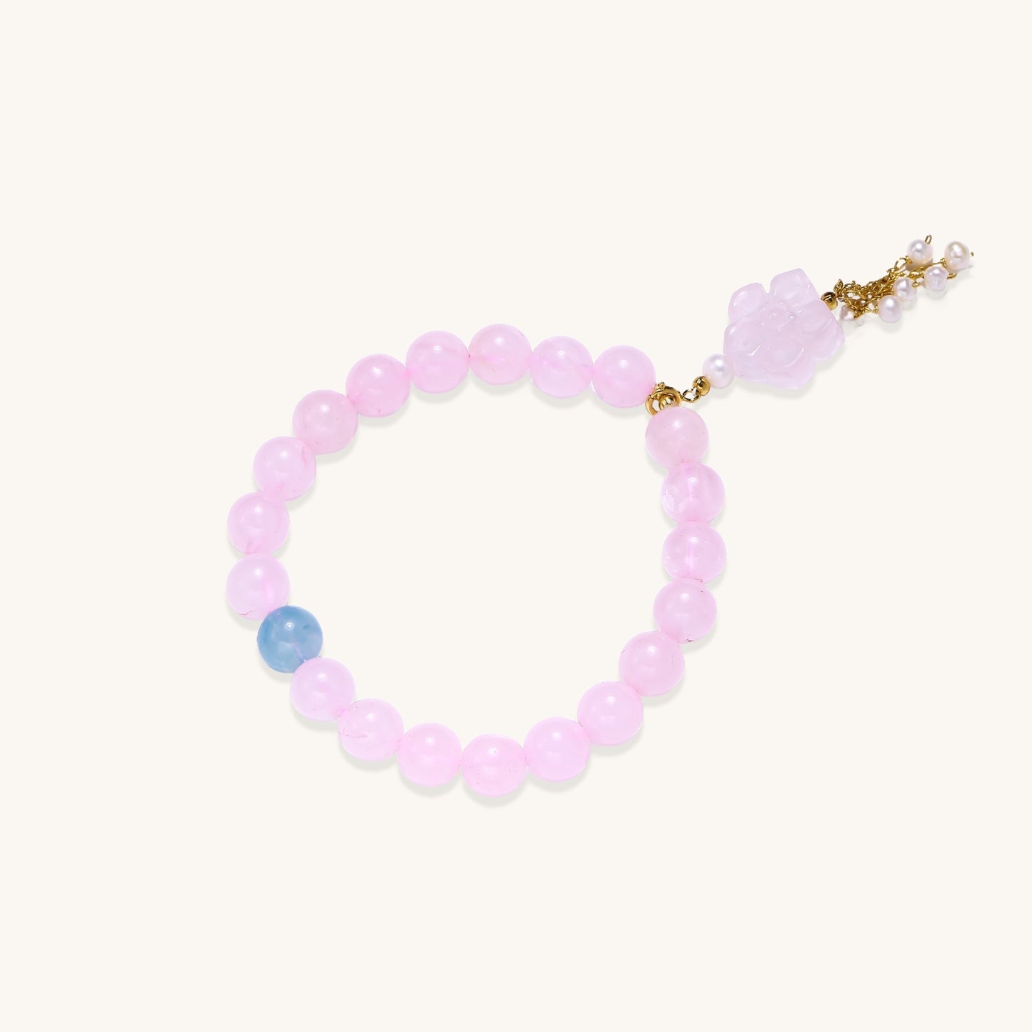 Beaded bracelet with pink rose quartz stones, blue aquamarine accent, and pearl chain details on white background